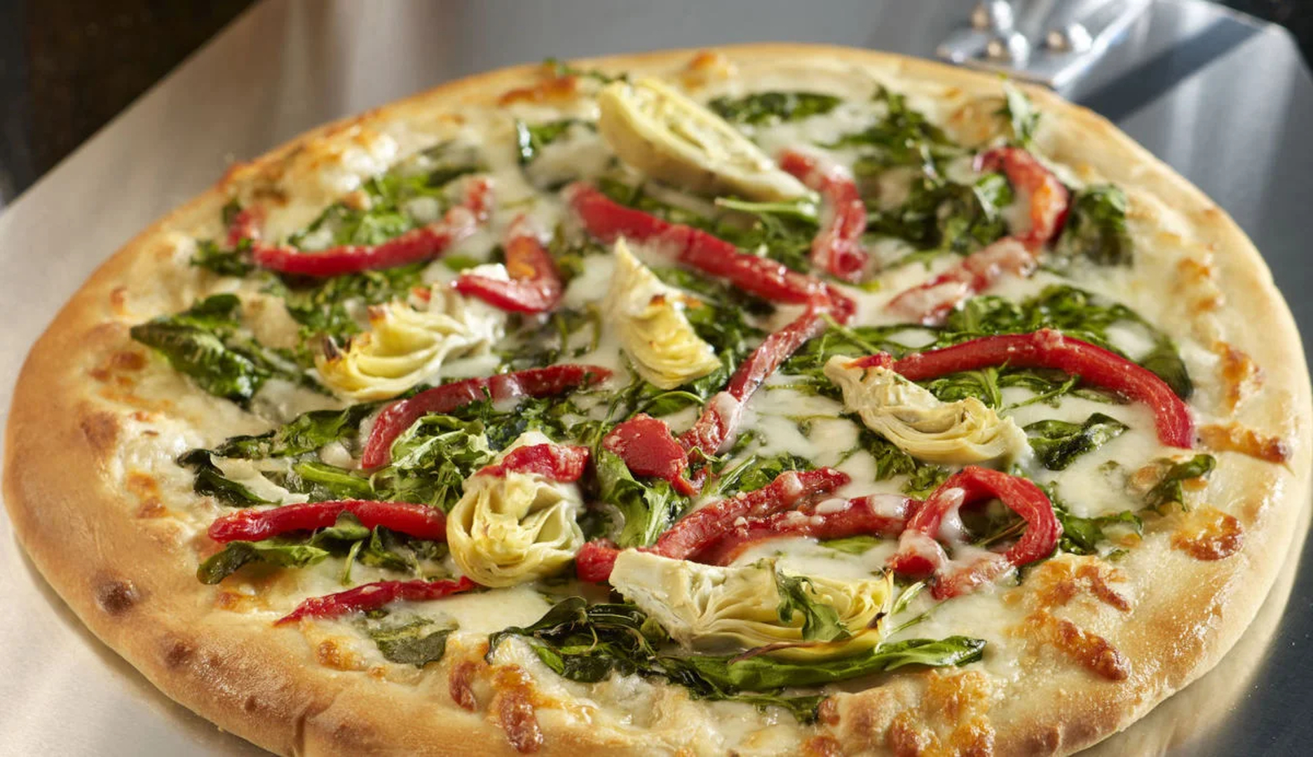White pizza with spinach, artichoke, and roasted red peppers